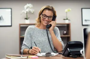 woman on the phone talking while in her small business office