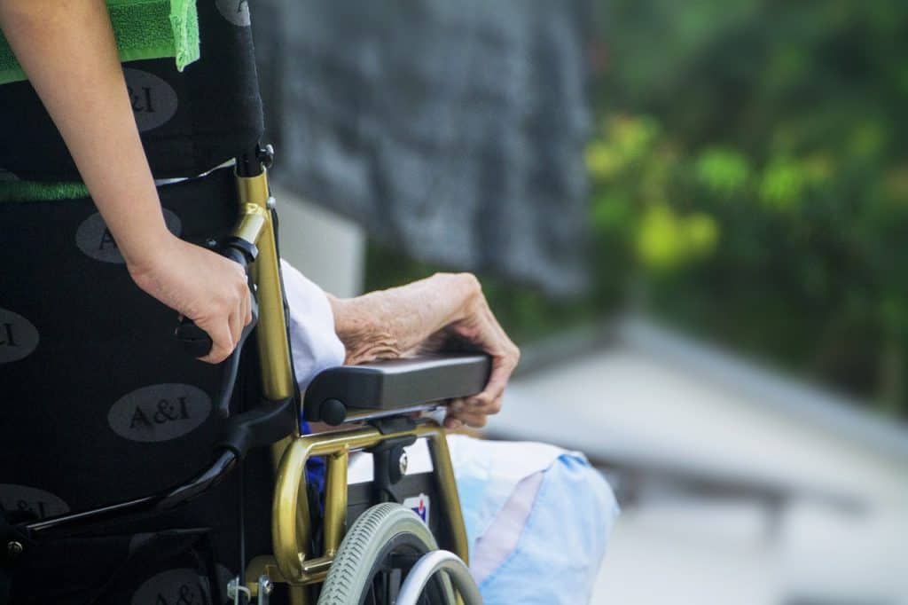 Image of a home health specialist with their patient who uses a hospice answering service