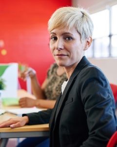 Image of a female employee in an office who has reported unethical behavior with a whistleblower hotline