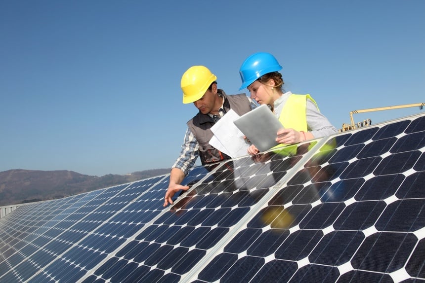 Image of two people inspecting solar panels for a solar power company that uses an answering service