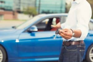 Image of a man handing over keys who works for a company that uses a car rental answering service