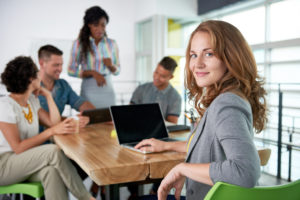 Image of five people in a conference room who are using an answering service for small businesses