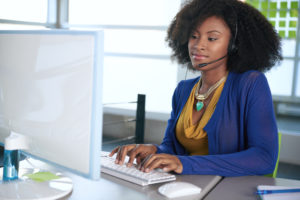 Image of a lady at a computer who is providing receptionist service for small businesses