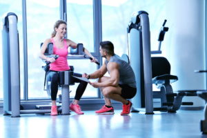 image of two people in a gym while a receptionist service for personal trainers take care of phone calls