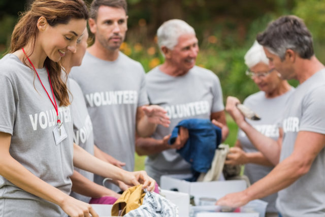 five volunteers that use a call center for non-profits while they sort donations