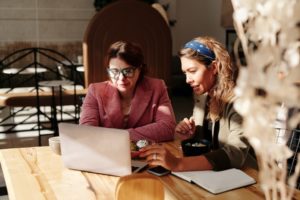 two women using social media to support a Black-owned business on a laptop