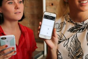 Image of two women and their phones using a live answering service for small business