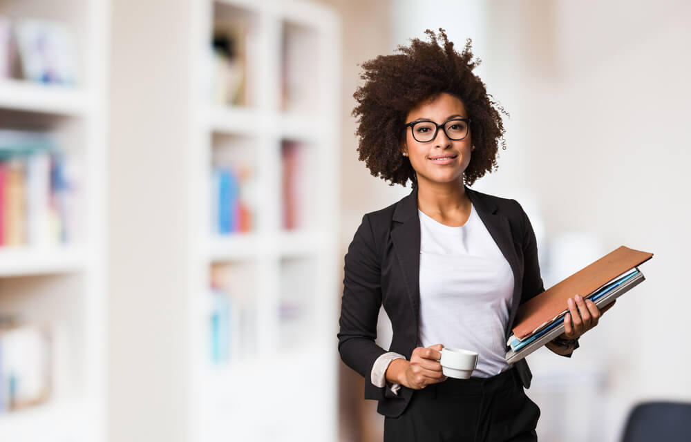 Businesswoman holding a cup of tea and documents