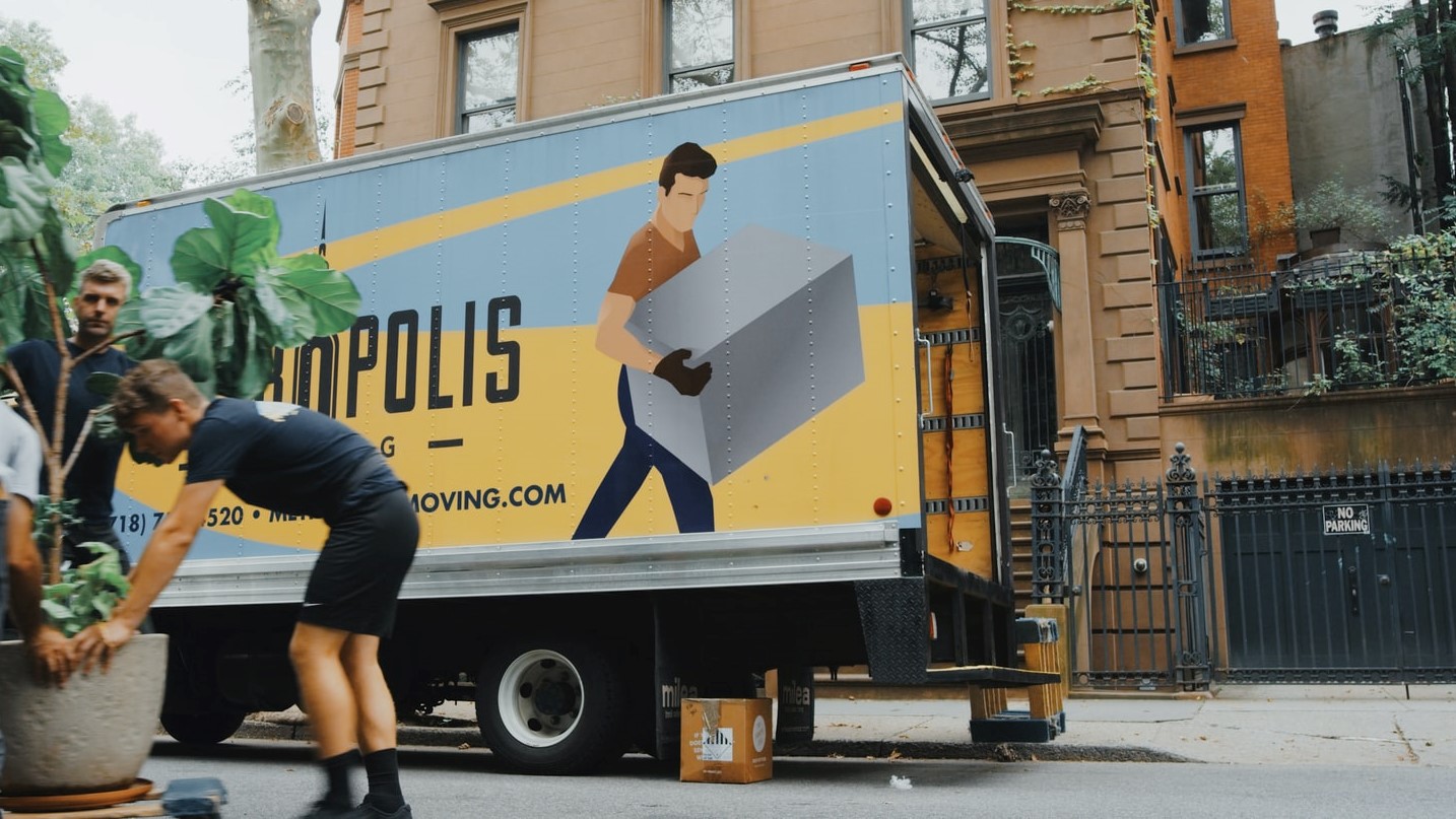 two men working for a moving company while an answering service handles their calls