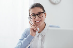 woman answering phone and looking into camera