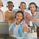 5 call center agents posing for a photo. They are smiling and giving thumbs up