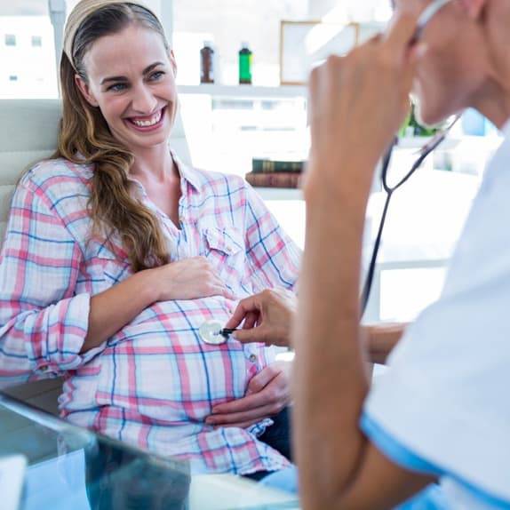 Image of a pregnant woman being examined by her doctor who uses an OBGYN answering service