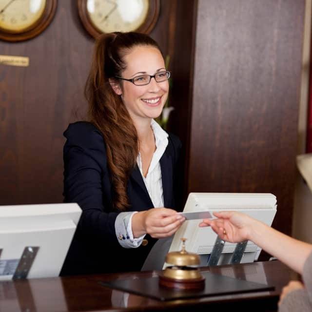 Image of front desk workers that use an answering service for hotels